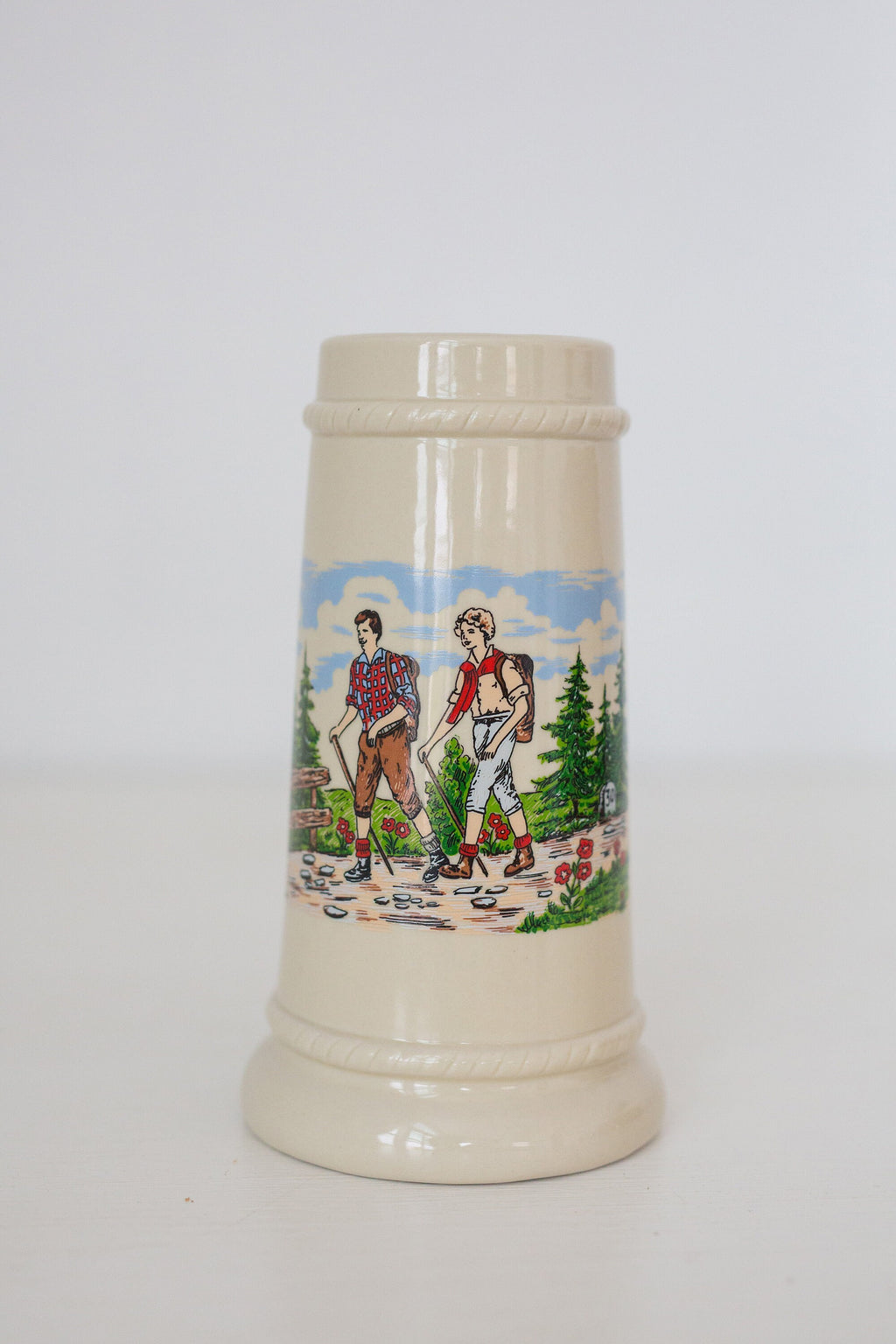 Vintage German beer stein with hiking image