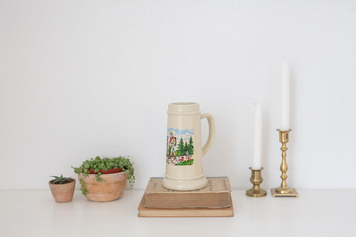 Vintage German beer stein with hiking image